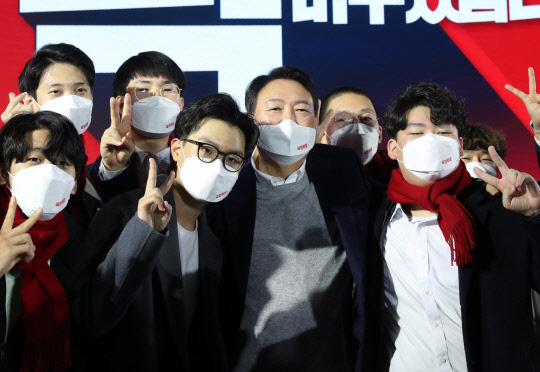 지난 12월6일 윤석열(가운데) 국민의힘 대선후보가 서울 송파구 올림픽공원 KSPO돔에서 중앙선거대책위원회 출범식을 마친 뒤 청년들과 사진을 찍고 있다.국회사진기자단·연합뉴스